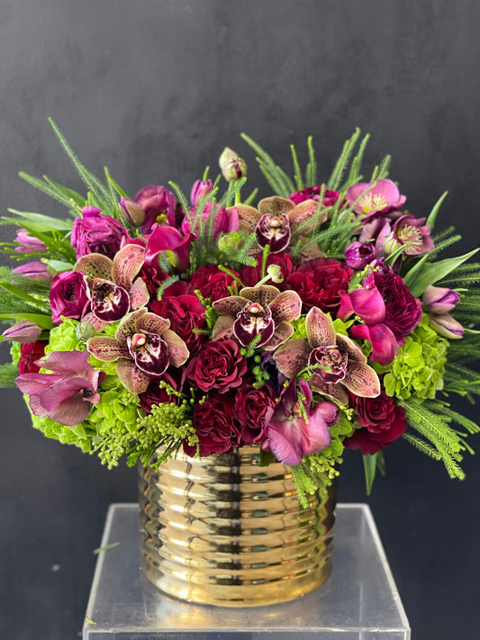 Mixed flower arrangement with gold round vase